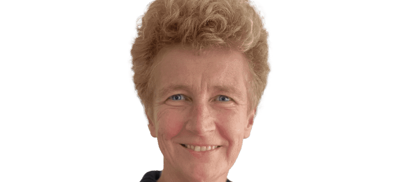 Eine Frau in einem schwarzen Pullover lächelt in die Kamera.